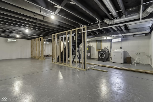 basement featuring water heater, electric panel, and independent washer and dryer