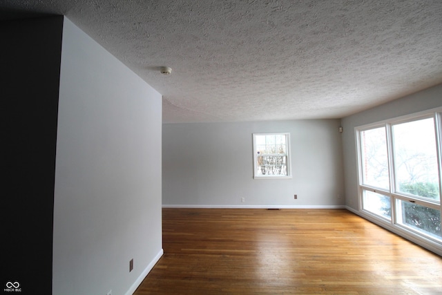 empty room featuring a textured ceiling and hardwood / wood-style floors