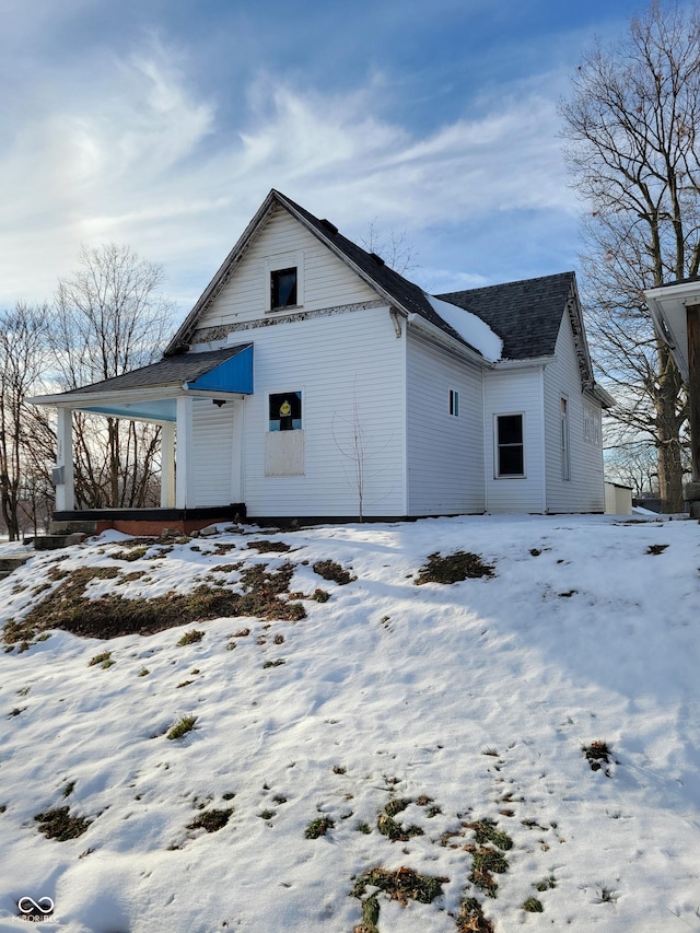 view of snow covered back of property