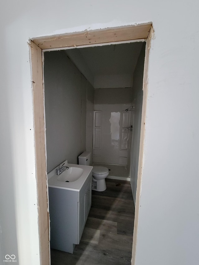 bathroom with toilet, vanity, and hardwood / wood-style flooring