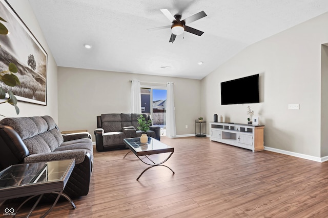 living room featuring a textured ceiling, ceiling fan, vaulted ceiling, and hardwood / wood-style floors