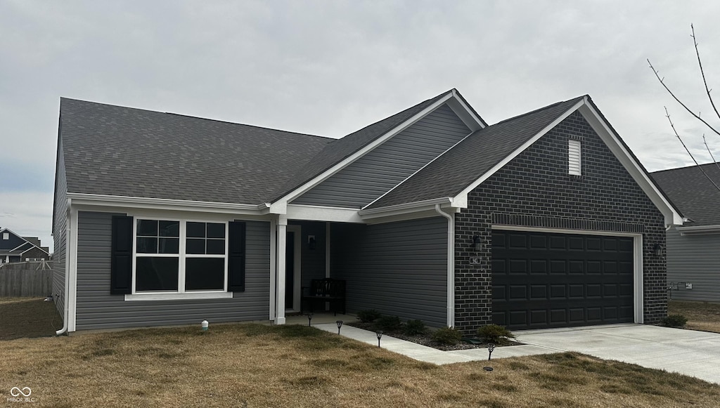 single story home with driveway, a garage, brick siding, roof with shingles, and a front yard