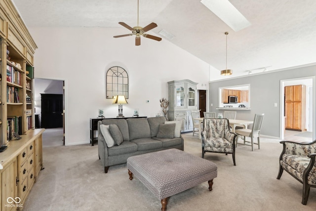 carpeted living room featuring a skylight, high vaulted ceiling, and ceiling fan