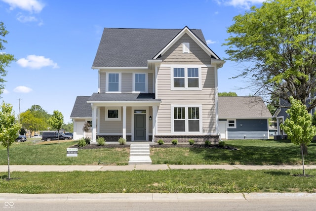 view of front of house with a garage, brick siding, a front lawn, and a porch