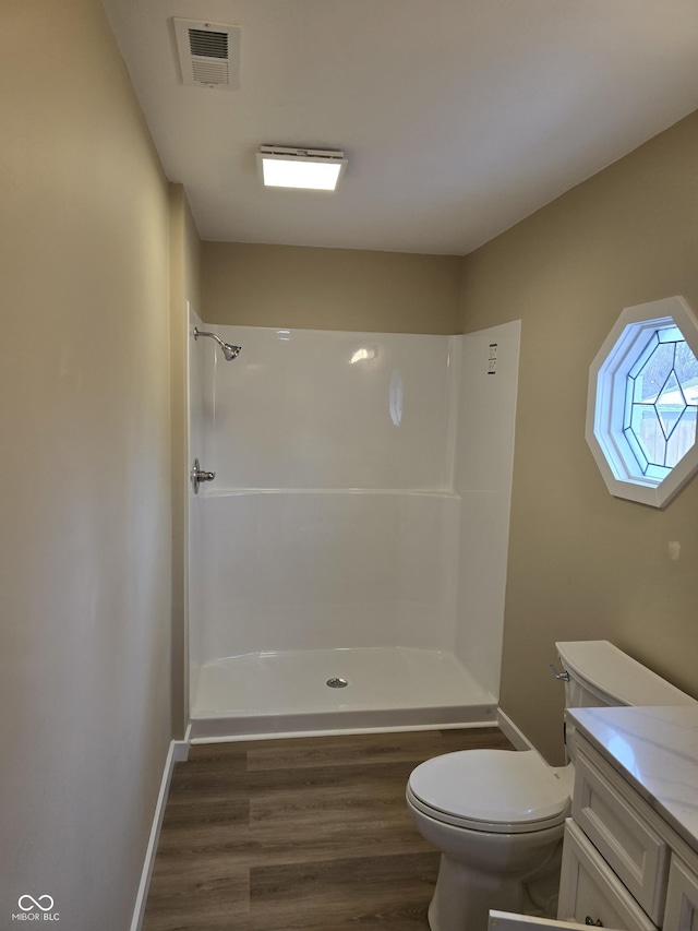 bathroom featuring toilet, walk in shower, hardwood / wood-style flooring, and vanity