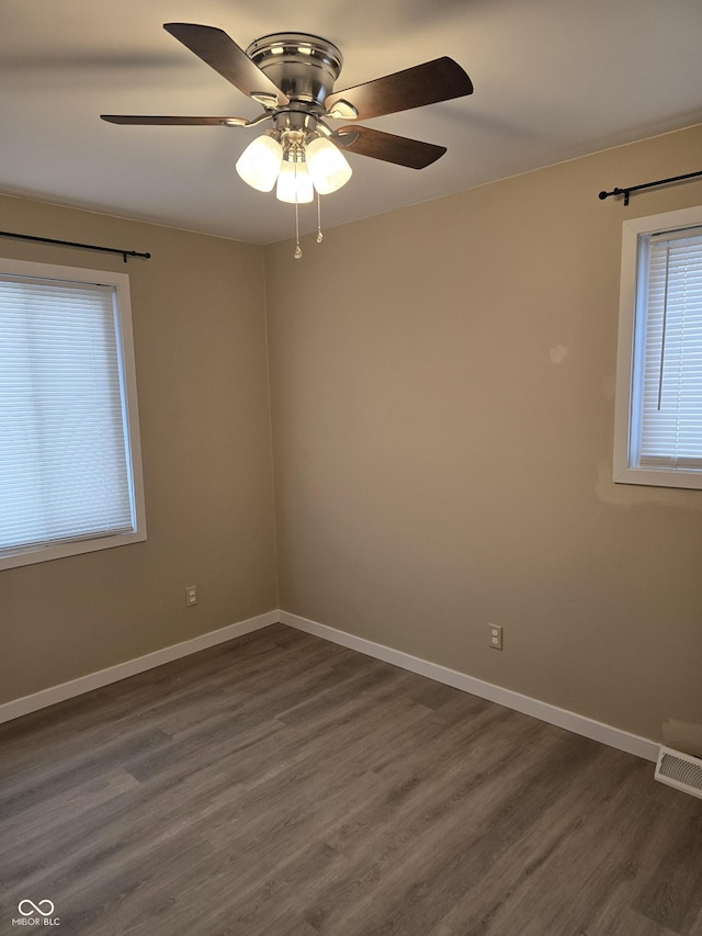 spare room with ceiling fan and dark hardwood / wood-style flooring