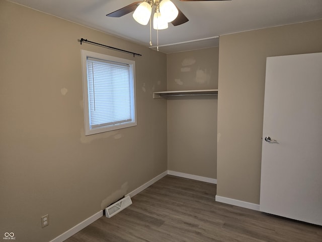 unfurnished bedroom featuring ceiling fan, a closet, and hardwood / wood-style flooring