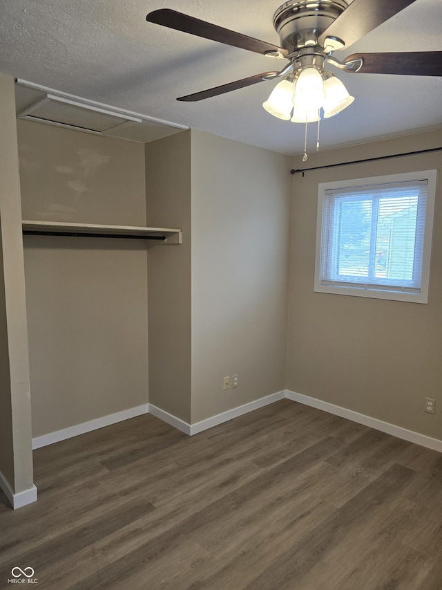 interior space with dark wood-type flooring, ceiling fan, and a textured ceiling