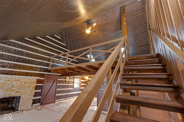 stairs with ceiling fan, lofted ceiling, and wood ceiling