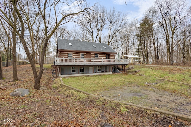 rear view of property with a wooden deck and a yard