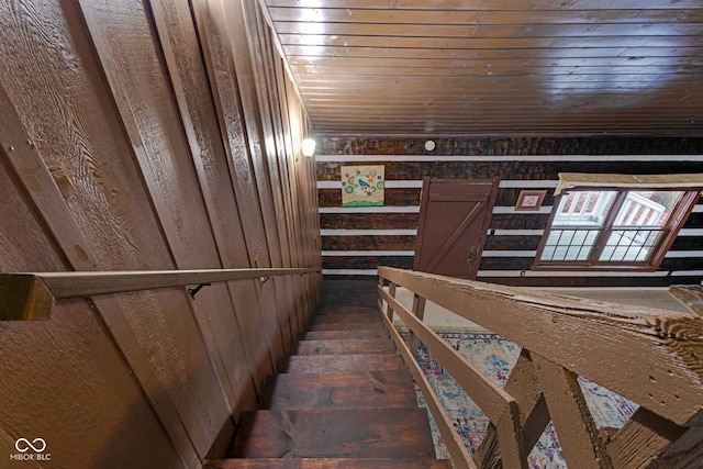 stairs featuring wooden walls and wood ceiling