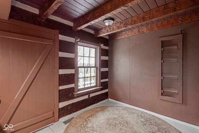 empty room with beamed ceiling and wooden ceiling