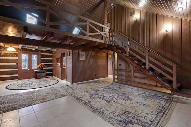 entrance foyer with high vaulted ceiling, wood ceiling, and wooden walls