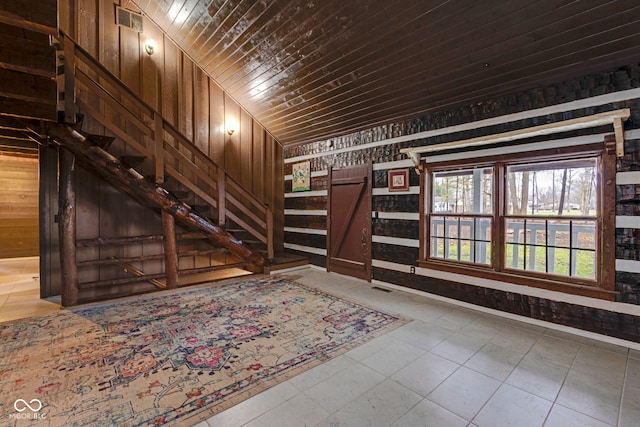 foyer featuring wood ceiling and wooden walls