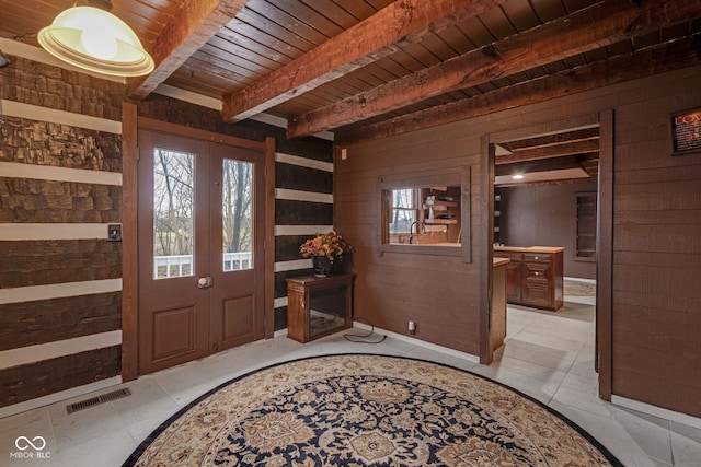 foyer featuring a wealth of natural light, wooden ceiling, wooden walls, and beamed ceiling