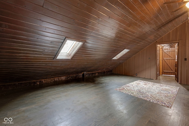 bonus room featuring wood-type flooring, vaulted ceiling with skylight, wooden ceiling, and wood walls