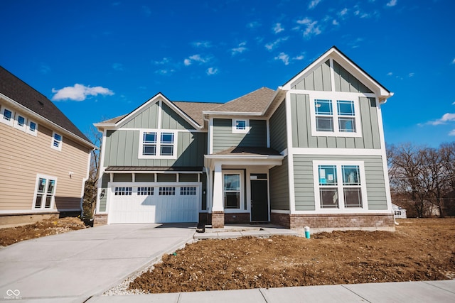 craftsman inspired home featuring concrete driveway, brick siding, board and batten siding, and an attached garage