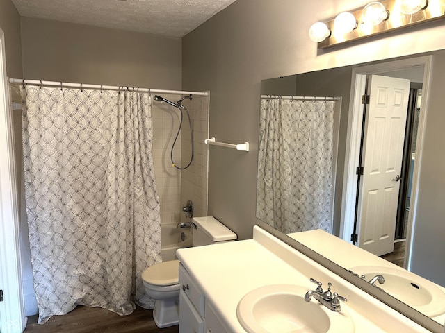 full bathroom featuring toilet, wood-type flooring, a textured ceiling, vanity, and shower / bath combination with curtain