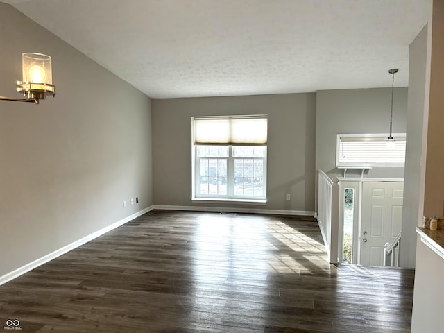 spare room featuring dark hardwood / wood-style flooring, a wealth of natural light, and lofted ceiling