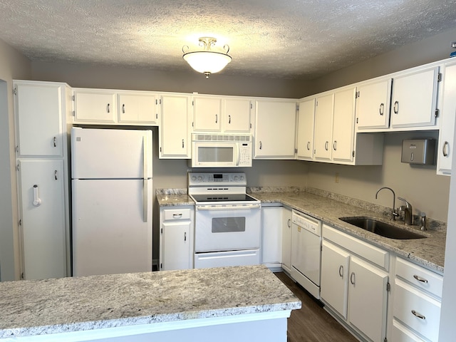 kitchen featuring white appliances, sink, a textured ceiling, and white cabinets