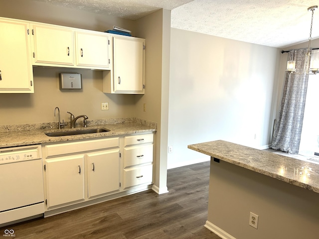 kitchen featuring white dishwasher, hanging light fixtures, sink, and a textured ceiling