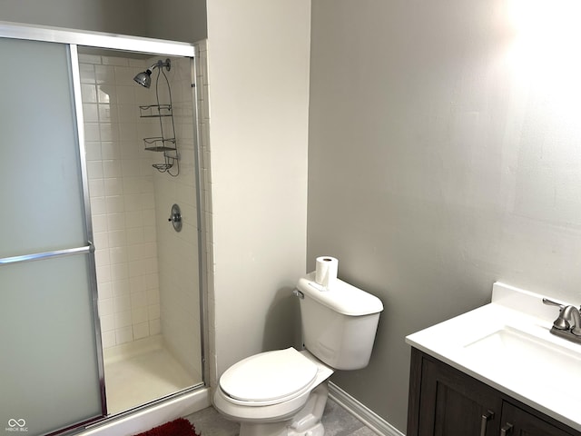 bathroom featuring vanity, toilet, and a shower with door