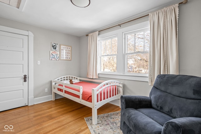 bedroom with baseboards and wood finished floors