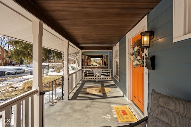 snow covered patio featuring covered porch