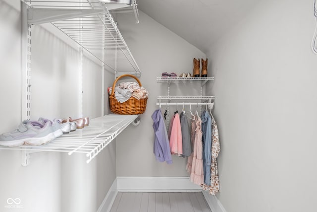 walk in closet featuring lofted ceiling and wood finished floors