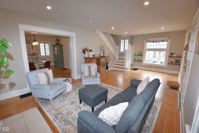 living area featuring recessed lighting, plenty of natural light, and stairway