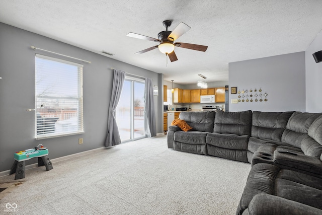 carpeted living room with a textured ceiling and ceiling fan