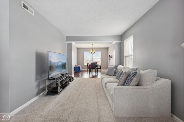 living room featuring a textured ceiling and a notable chandelier