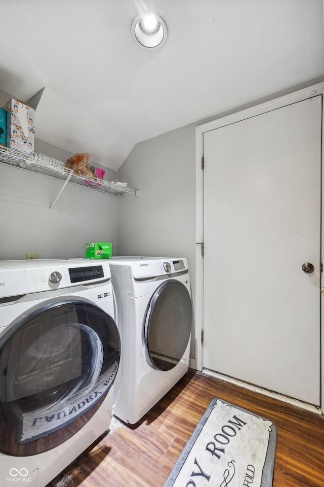 clothes washing area featuring dark hardwood / wood-style flooring and washing machine and clothes dryer