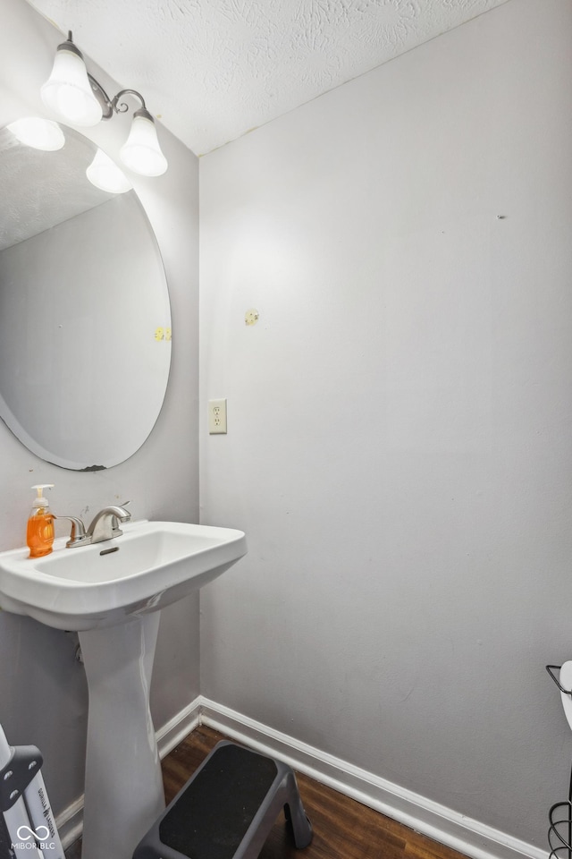 bathroom with wood-type flooring, sink, and a textured ceiling