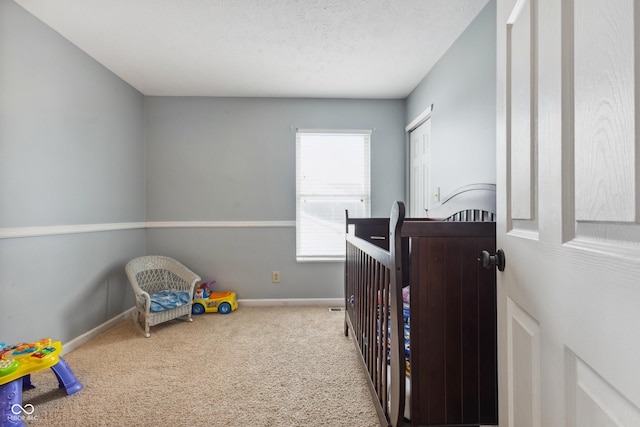 bedroom featuring a textured ceiling, light colored carpet, and multiple windows