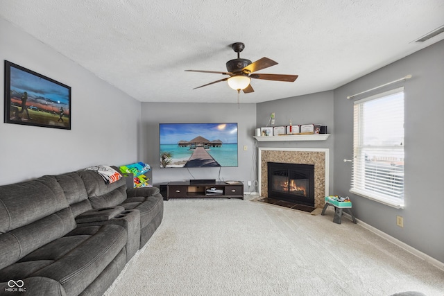 carpeted living room with ceiling fan and a textured ceiling