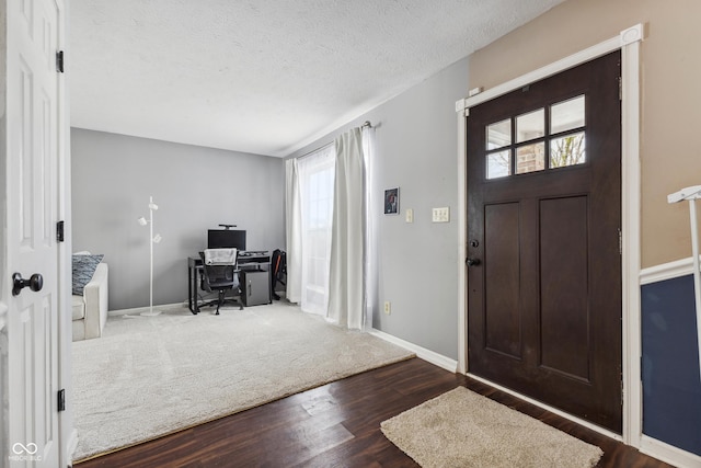 entryway featuring a textured ceiling, a wealth of natural light, and hardwood / wood-style flooring