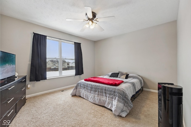 carpeted bedroom with ceiling fan and a textured ceiling