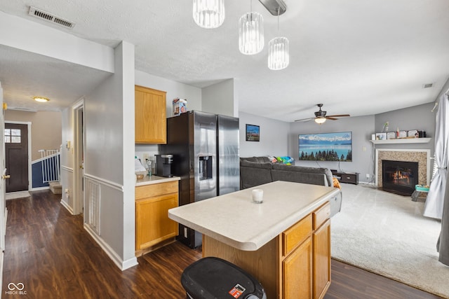 kitchen featuring decorative light fixtures, ceiling fan, dark hardwood / wood-style floors, a kitchen island, and a textured ceiling