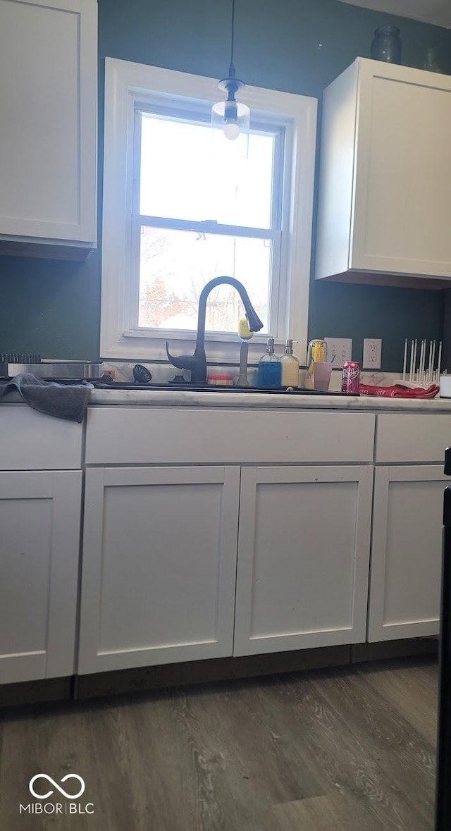 kitchen featuring white cabinetry, pendant lighting, dark hardwood / wood-style floors, and sink