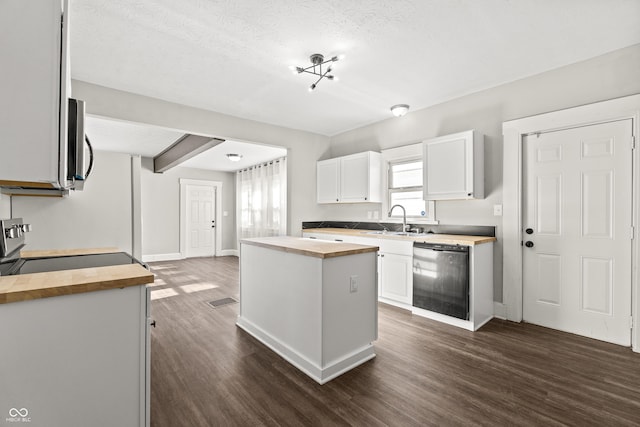 kitchen with butcher block counters, dishwasher, a kitchen island, and white cabinets