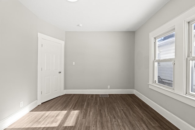 unfurnished room with dark hardwood / wood-style floors