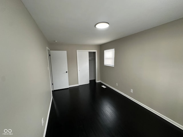 unfurnished bedroom with a closet and hardwood / wood-style flooring