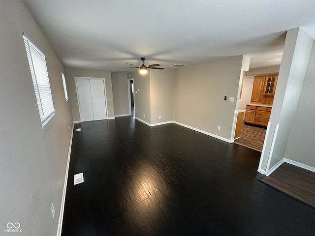 unfurnished room featuring dark wood-type flooring, a wealth of natural light, and ceiling fan