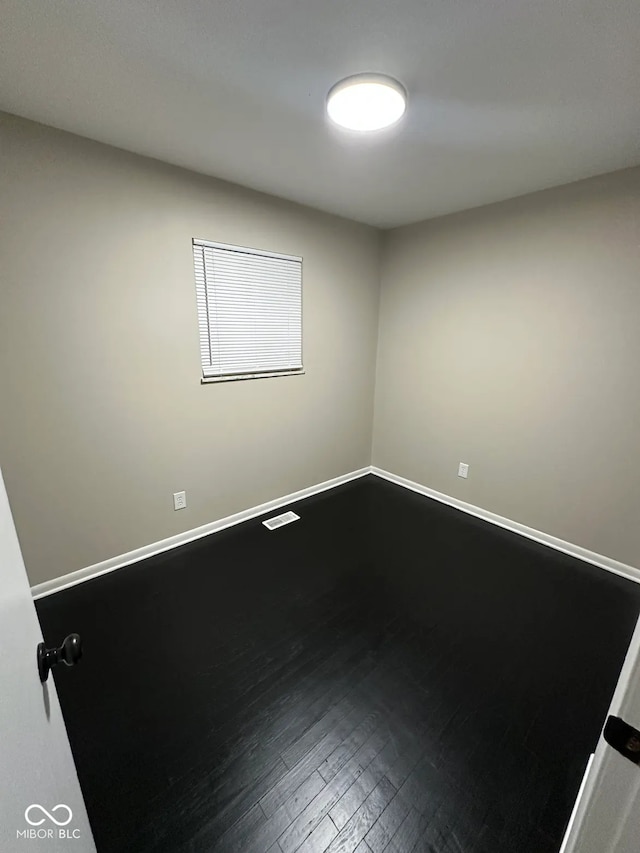 spare room featuring wood-type flooring