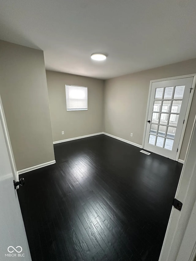 unfurnished room with dark wood-type flooring