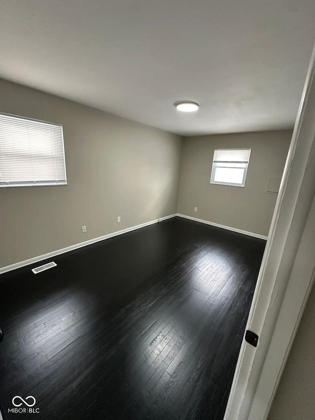 empty room with dark wood-type flooring