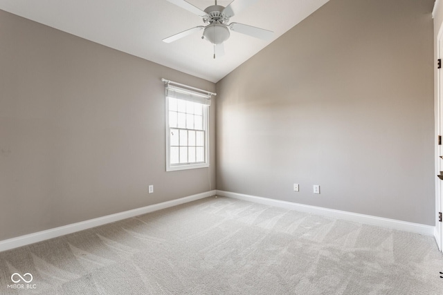 spare room featuring lofted ceiling, baseboards, and light carpet