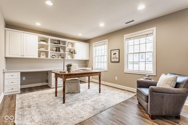 home office featuring visible vents, wood finished floors, built in desk, recessed lighting, and baseboards