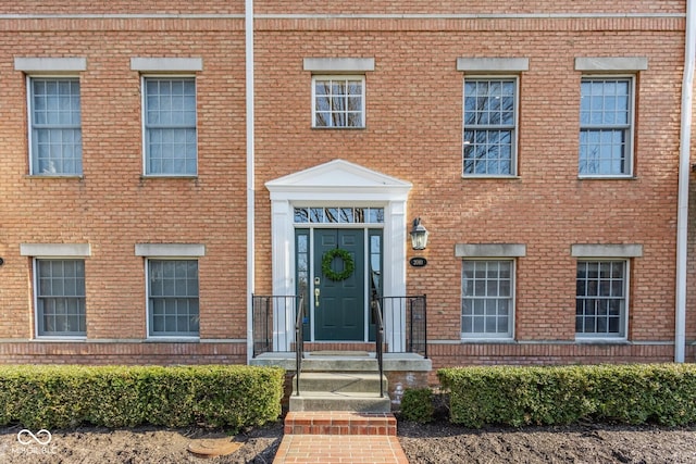 view of exterior entry featuring brick siding